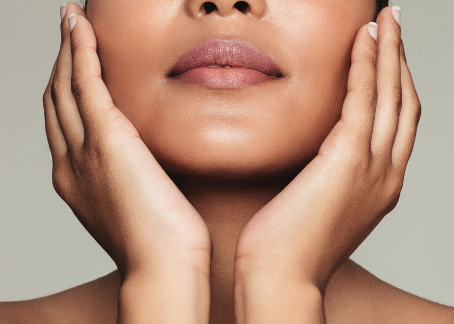 close up of woman touching glowing face