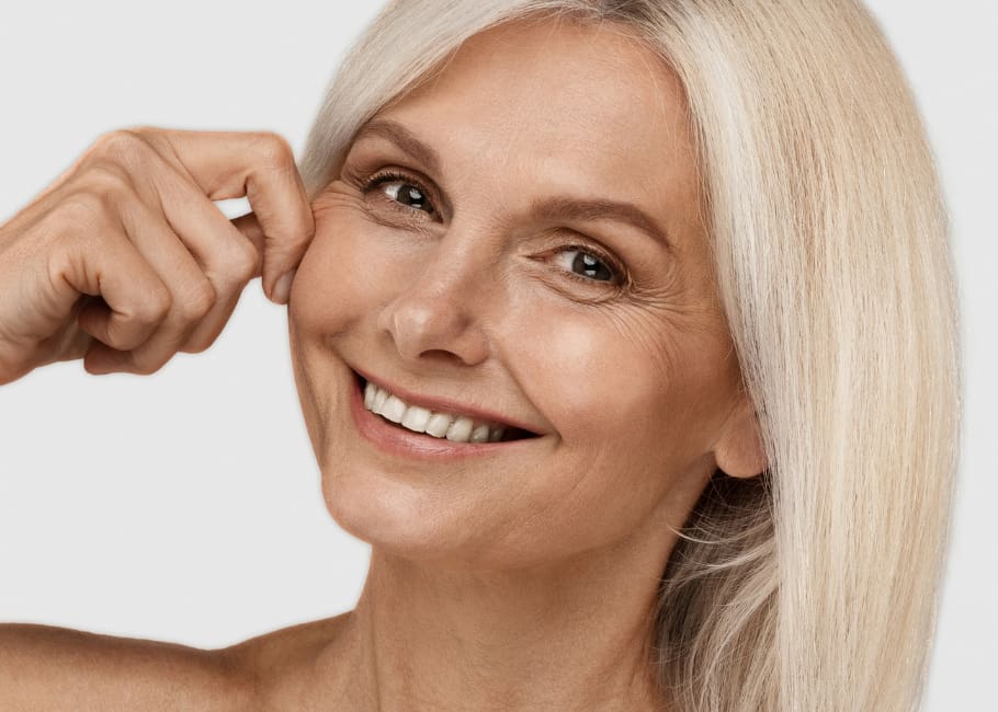 older woman pinching cheek after filler