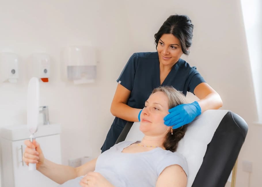 woman looking into mirror after skin booster treatment