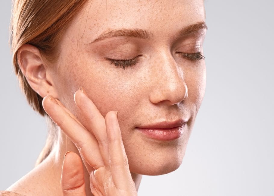 woman touching her cheek after filler